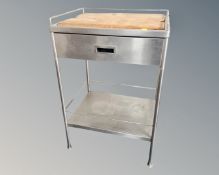 A stainless steel medical two tier trolley fitted a drawer with pine chopping board inset