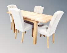 A contemporary oak extending dining table fitted a leaf together with four chairs upholstered in