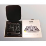 A Hover Camera Passport flying camera drone in box with instructions battery and charger.