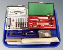 A tray of drawing instruments, wooden and plastic slide rules,