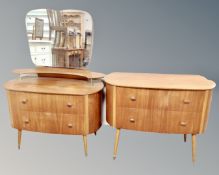 A 20th century teak two drawer dressing table on raised legs together with matching two drawer