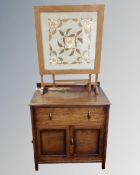 A 1930s oak double door linen cabinet fitted with a drawer,