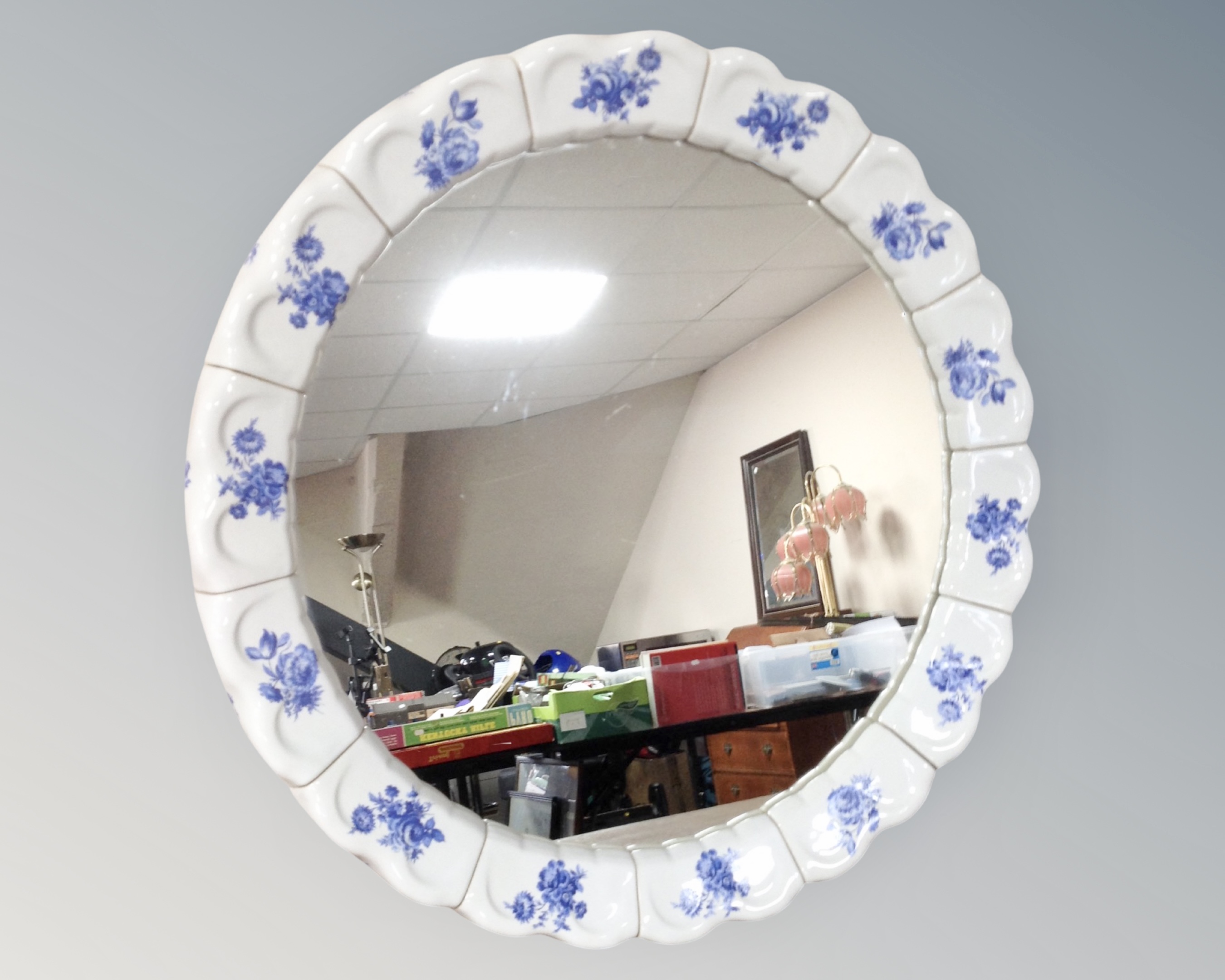 A circular blue and white ceramic framed mirror