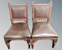 A pair of 19th century carved oak Gothic low chairs in brown leather