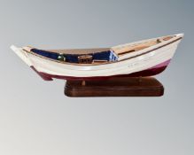 A wooden model boat Dawn Run, on stand.