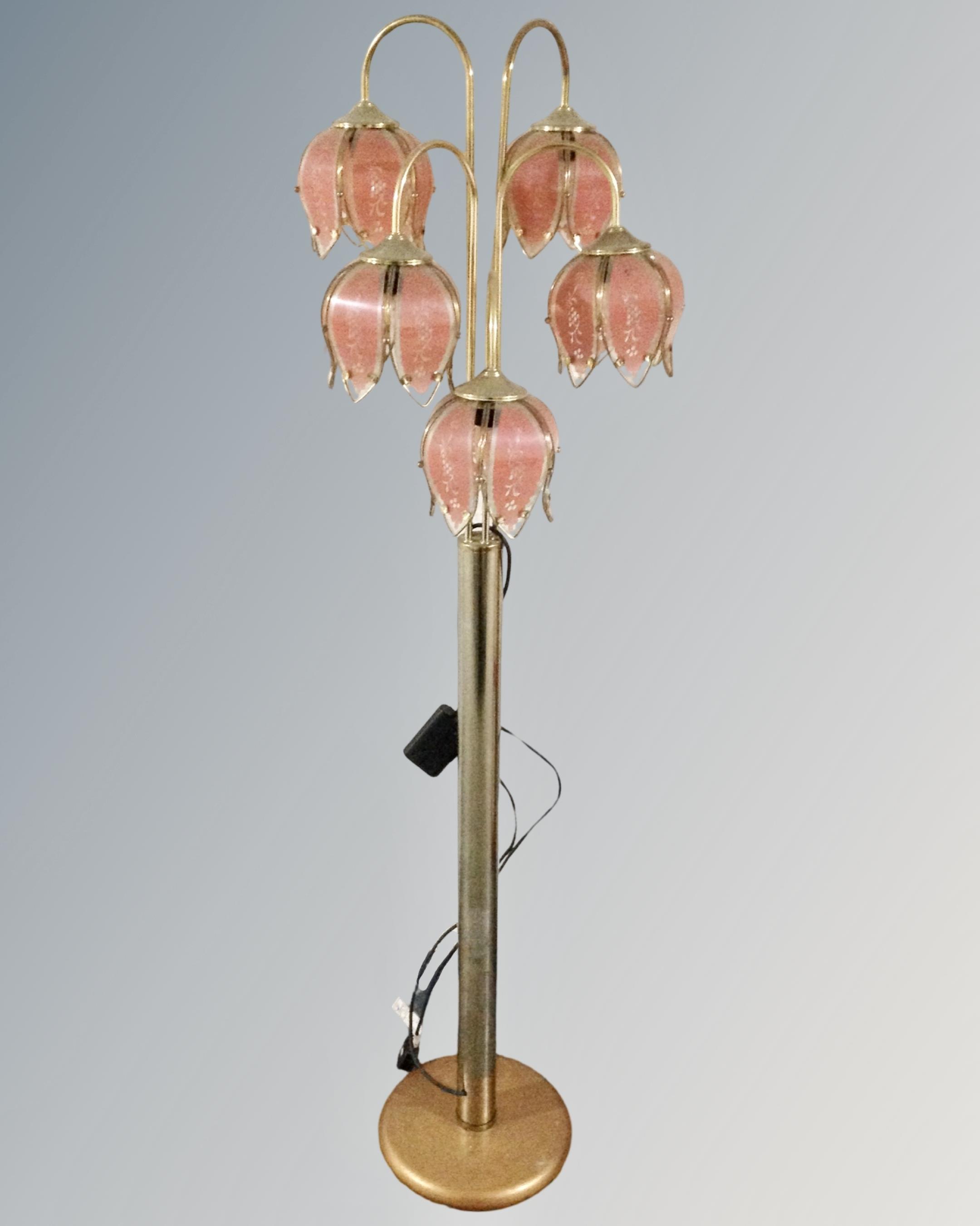 A brass five-way floor lamp with glass shades in the form of flower heads