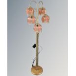 A brass five-way floor lamp with glass shades in the form of flower heads
