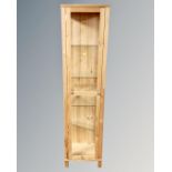 A contemporary pine and glass sentry door display cabinet with shelves