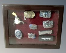 A counter topped display box containing seven assorted belt buckles including Smith and Wesson,