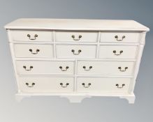 A painted pine nine drawer block chest with brass drop handles, 144 cm x 48 cm x 93 cm.