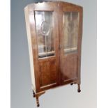 A 1930's oak double door glazed bookcase on raised legs 93 cm x 33 cm x 173 cm.