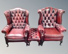 A pair of oxblood Chesterfield buttoned leather wingback armchairs with matching stool