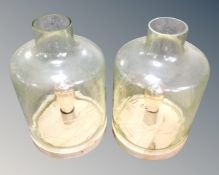 A pair of contemporary glass hurricane table lamps on stands