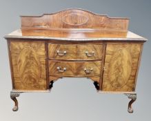 A 19th century mahogany shaped fronted double door sideboard with two central doors on claw and