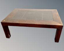 A contemporary coffee table with inset leather panel