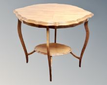 An Edwardian mahogany two tier shaped occasional table
