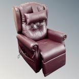 An electric reclining wingback armchair in maroon leather