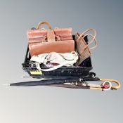 A crate containing assorted lady's handbags, vintage leather briefcases, parasols etc.