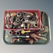 A tray containing a collection of wooden pipes.