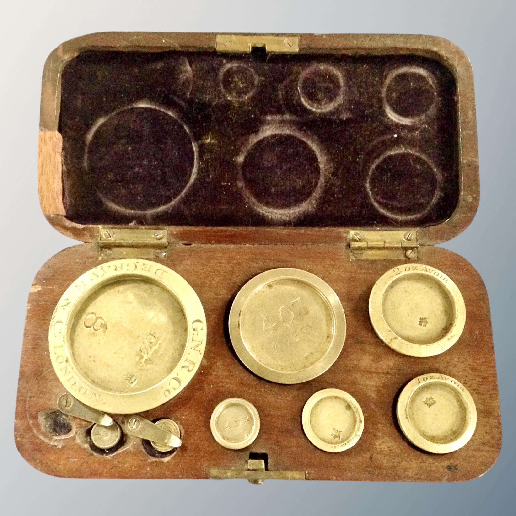 A set of George III brass weights in a fitted mahogany box.
