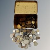 A vintage tea tin containing 20th century British and foreign coins.