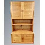 A teak bookcase fitted cupboards and drawers,