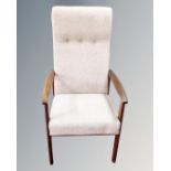 A 20th century stained beech armchair upholstered in an oatmeal fabric.