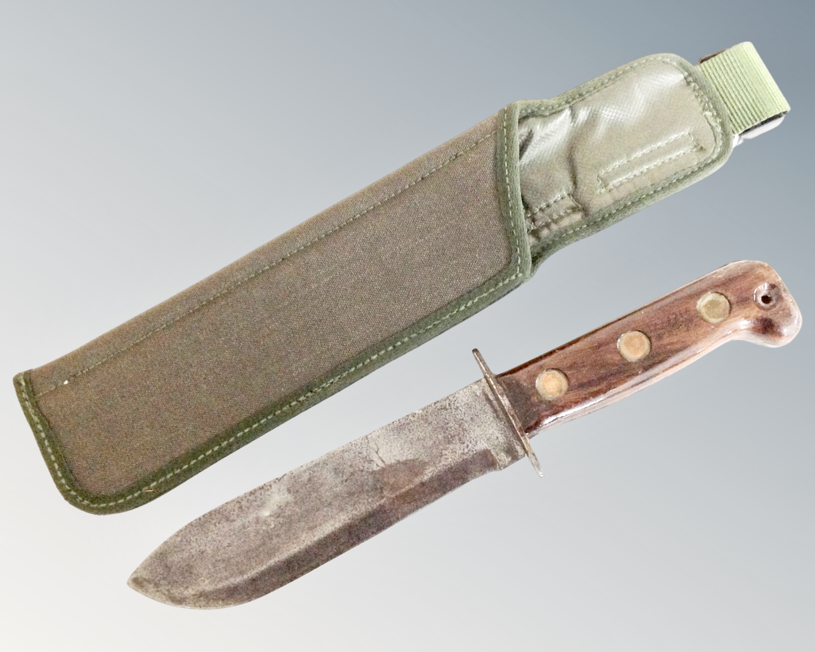 A British Army survival knife with arrow and B2 markings, in canvas scabbard.