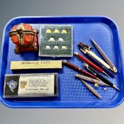 A tray containing coronation related pens, a cast iron Queen Elizabeth coronation money box,