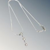 An 18ct white gold three stone diamond necklace, approximately 0.