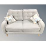 A Pamplona two seater sofa in natural grey fabric with two Etta mallow scatter cushions retailed by