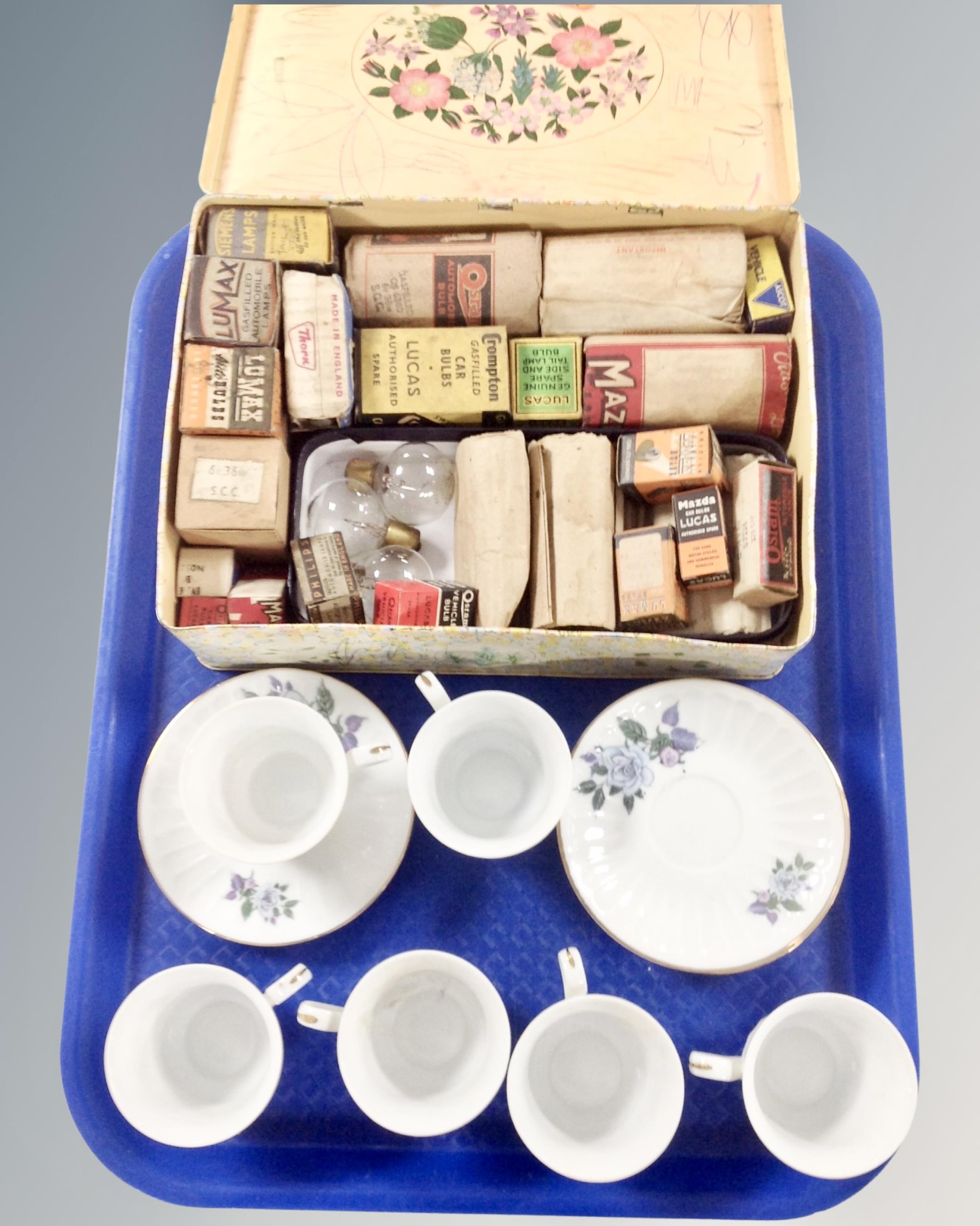 Six Chinese teacups and saucers together with a vintage tin containing assorted bulbs.