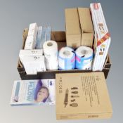 A box containing cooling gel pillows, sonic facial dermaplaning tools, kitchen roll,
