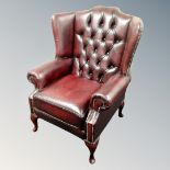 A Chesterfield wingback oxblood leather armchair