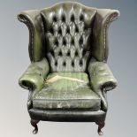 A Chesterfield wingback buttoned green leather armchair