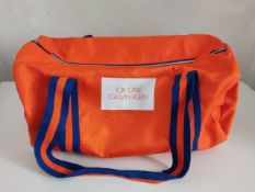 A Calvin Klein CK One Orange duffle bag (New).