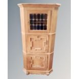 A continental light oak corner cabinet.