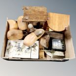 A box containing vintage wooden pieces including clogs, book troughs, oversized rattle,