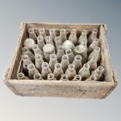A vintage pine crate containing glass milk bottles