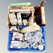 Two boxes containing glassware, new china mugs, a counter top cigar box, games etc.