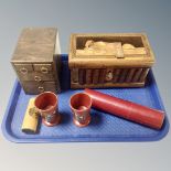 A tray containing a Sorrento puzzle box in the form of a book, Japanese lacquered beakers,