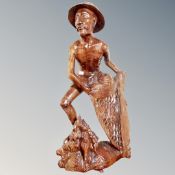 An Indonesian carved wooden figure of a fisherman.