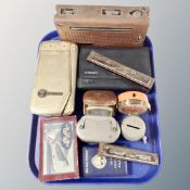 A tray containing mid-20th century money boxes and desk clocks, harmonicas, vintage radios,