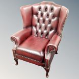 A Chesterfield wingback oxblood leather armchair
