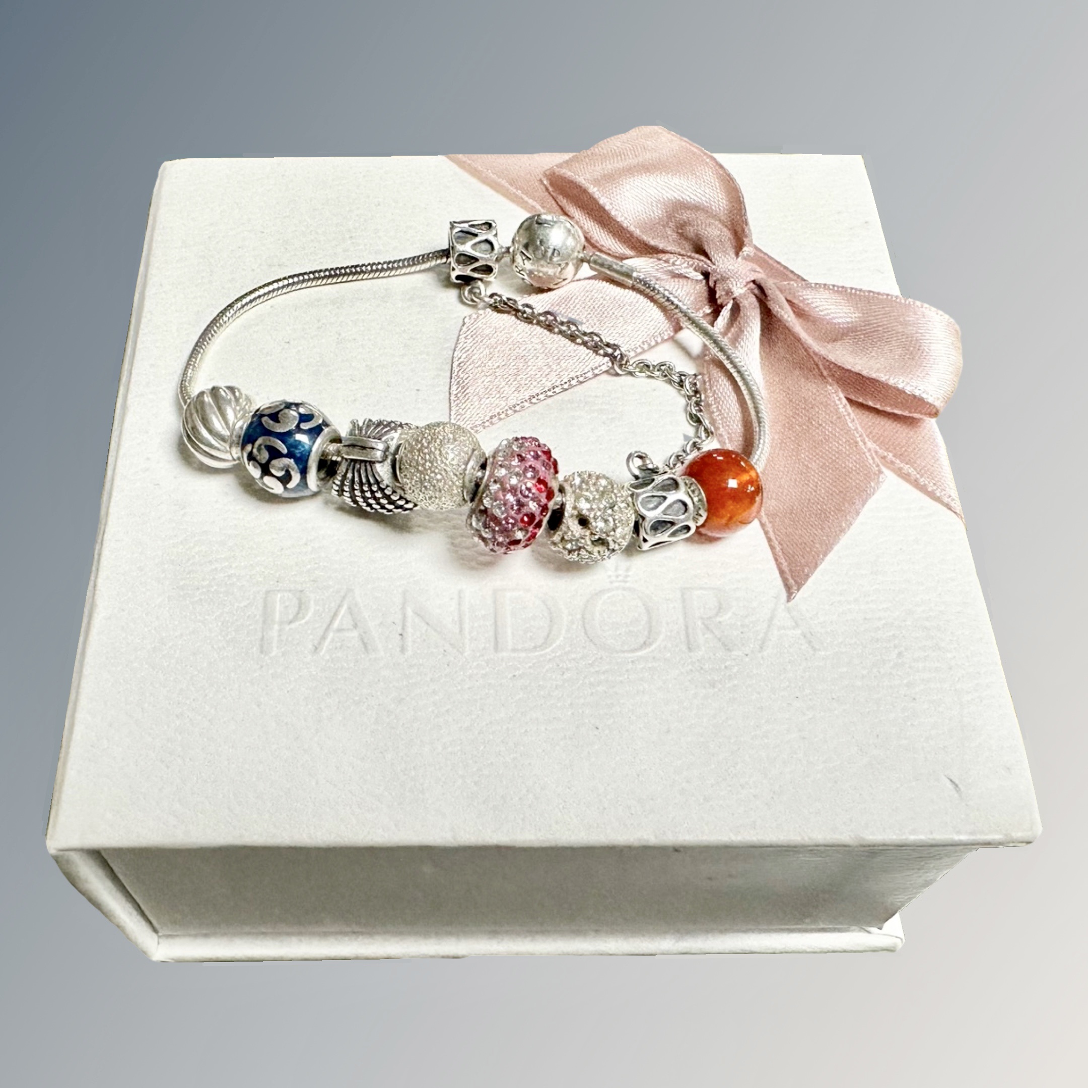 A boxed Pandora bracelet with approximately 9 beads.