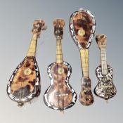 Four antique tortoiseshell miniature musical instruments with mother of pearl inlay.