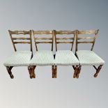 A set of four continental oak dining room chairs upholstered in green striped fabric.
