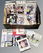 A box containing a quantity of late 20th and early 21st century Newcastle United match day and cup