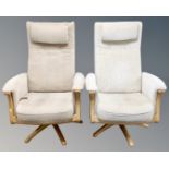 A pair of Ercol Gina manual reclining armchairs upholstered in beige fabric with headrests and