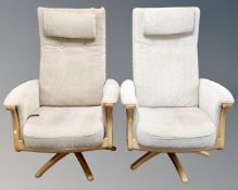 A pair of Ercol Gina manual reclining armchairs upholstered in beige fabric with headrests and